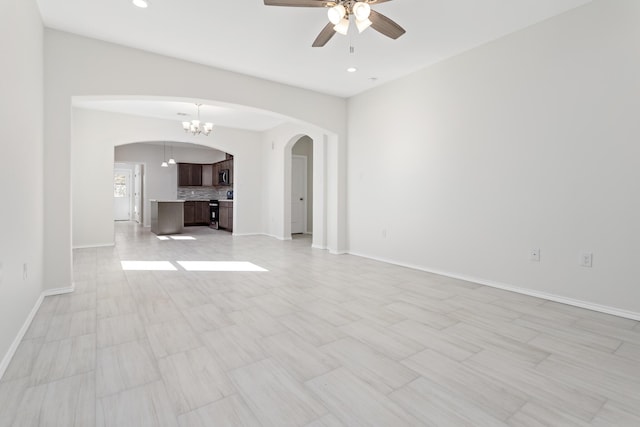 unfurnished living room with ceiling fan with notable chandelier