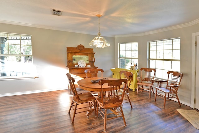 dining area featuring a healthy amount of sunlight, dark hardwood / wood-style floors, ornamental molding, and a notable chandelier