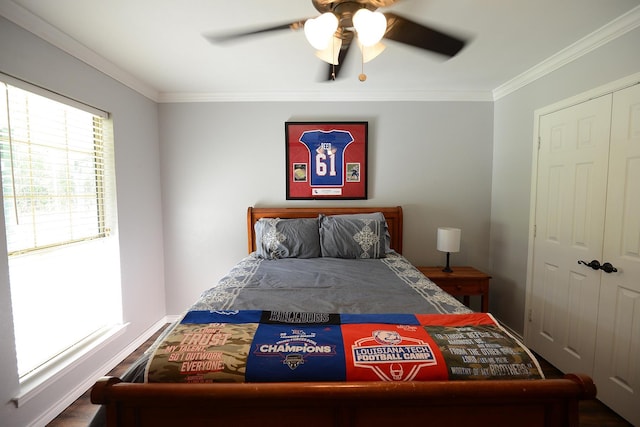 bedroom featuring a closet, multiple windows, ceiling fan, and crown molding