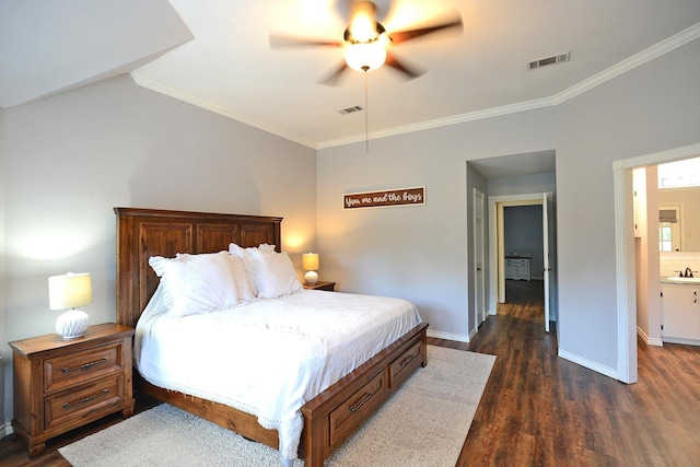 bedroom featuring dark hardwood / wood-style flooring, ensuite bathroom, ceiling fan, and ornamental molding