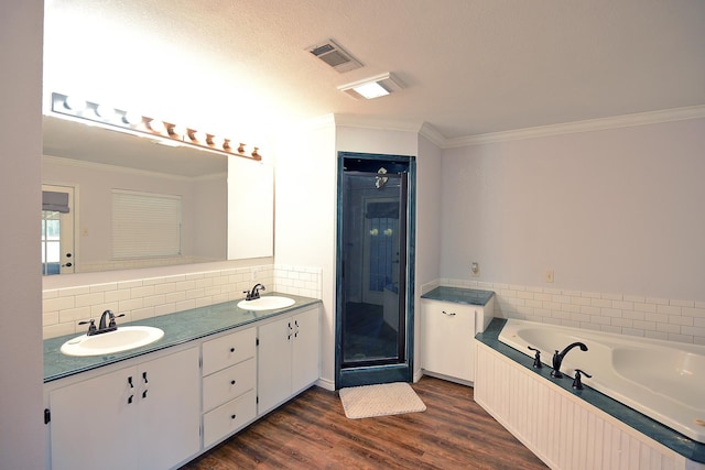 bathroom with a bathtub, ornamental molding, vanity, a textured ceiling, and hardwood / wood-style flooring