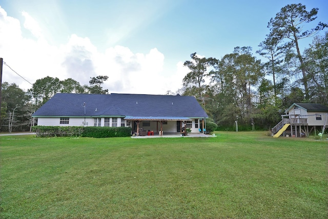 back of house featuring a lawn and a patio