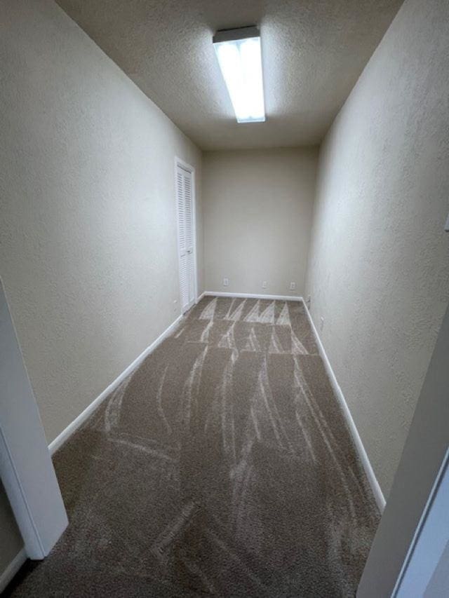 carpeted spare room featuring a textured ceiling