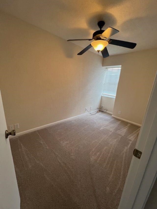 unfurnished room with carpet floors and ceiling fan