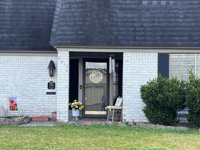 view of exterior entry featuring a yard