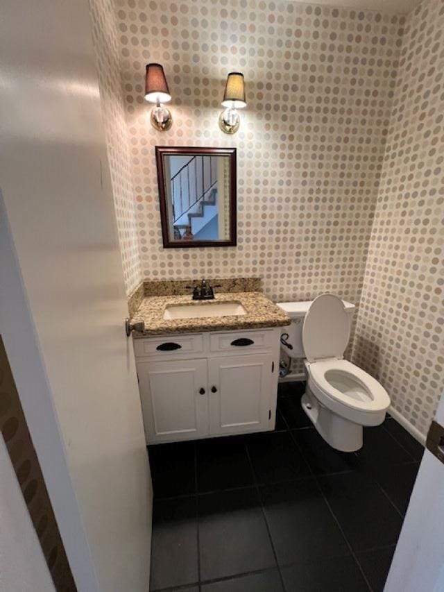 bathroom featuring vanity, tile patterned floors, and toilet