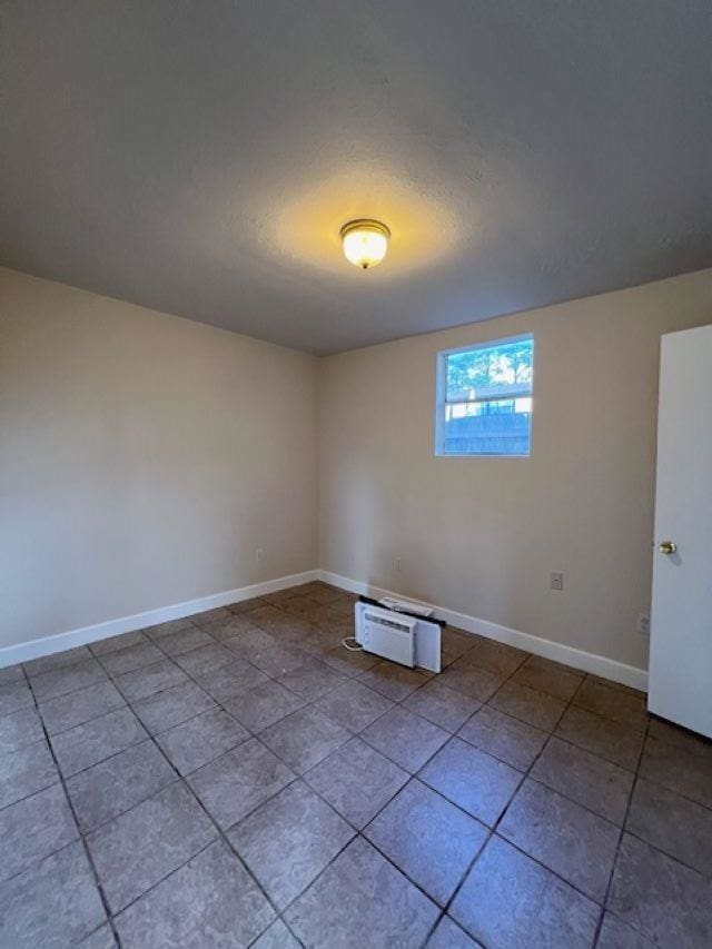 tiled spare room featuring a textured ceiling