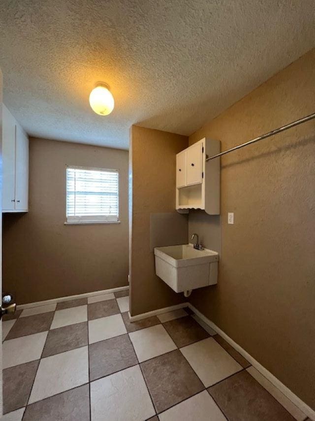 laundry room with sink and a textured ceiling