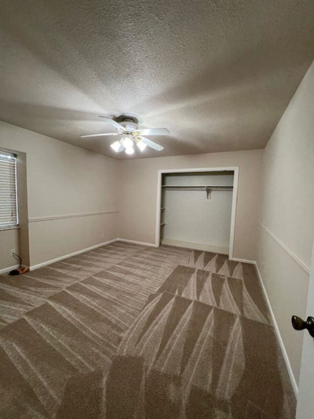 unfurnished bedroom featuring ceiling fan, carpet flooring, a closet, and a textured ceiling