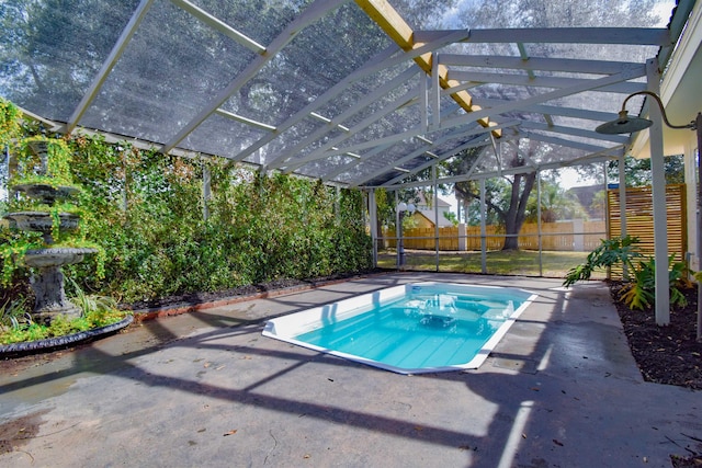 view of swimming pool featuring a lanai and a patio