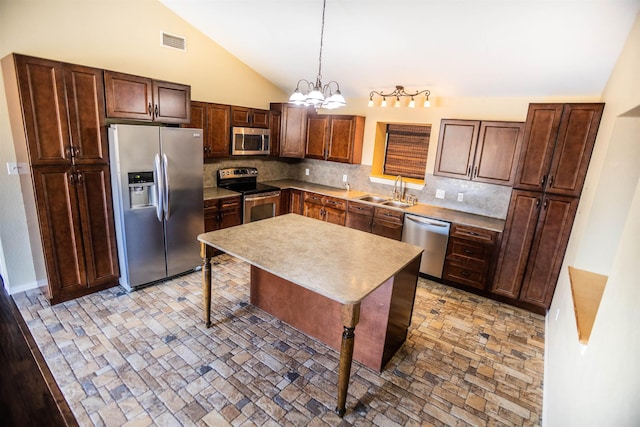 kitchen with sink, a chandelier, hanging light fixtures, appliances with stainless steel finishes, and backsplash