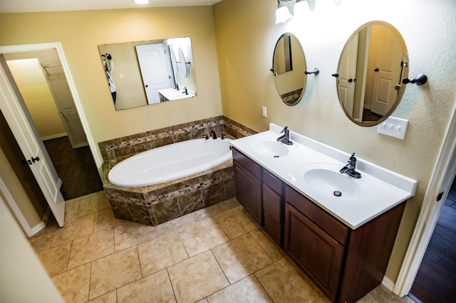 bathroom with vanity, tile patterned flooring, and tiled bath