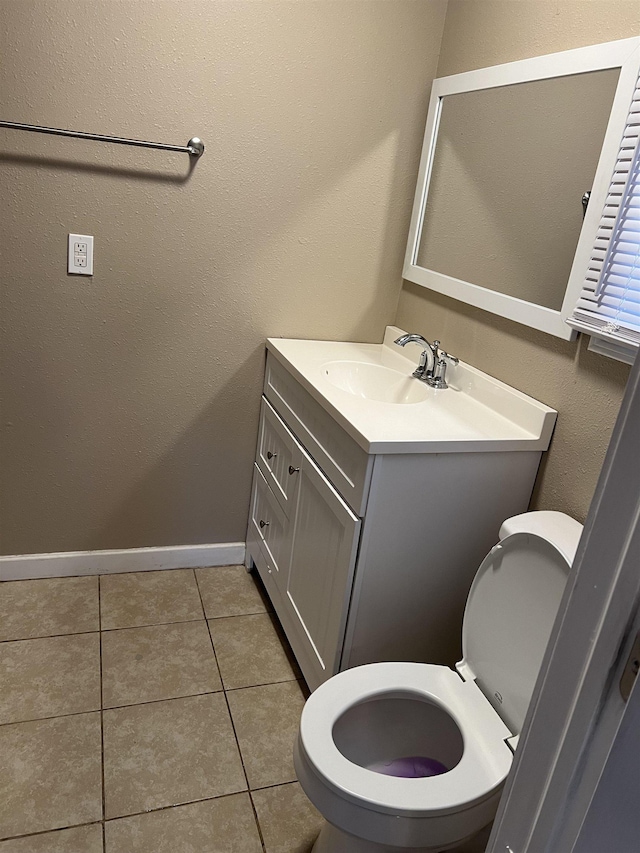 bathroom with toilet, tile patterned floors, and vanity