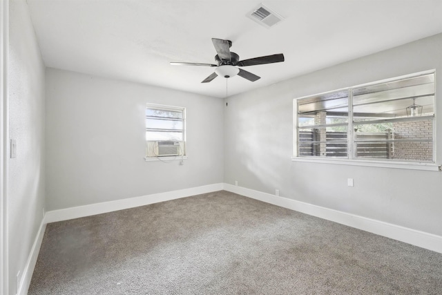 carpeted empty room with cooling unit, baseboards, a ceiling fan, and visible vents