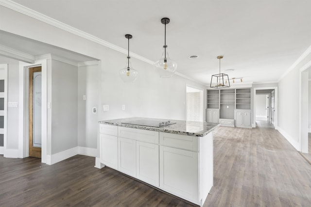 kitchen with dark wood-type flooring, decorative light fixtures, crown molding, and light stone counters