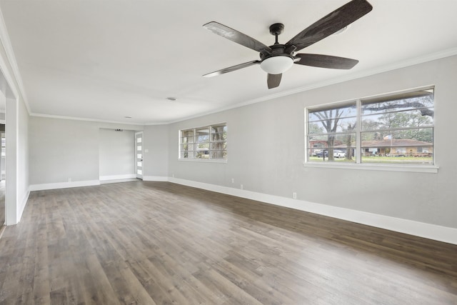 spare room featuring dark wood-type flooring, crown molding, and baseboards