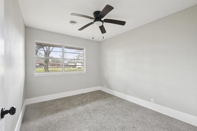 carpeted empty room with baseboards, a ceiling fan, and visible vents