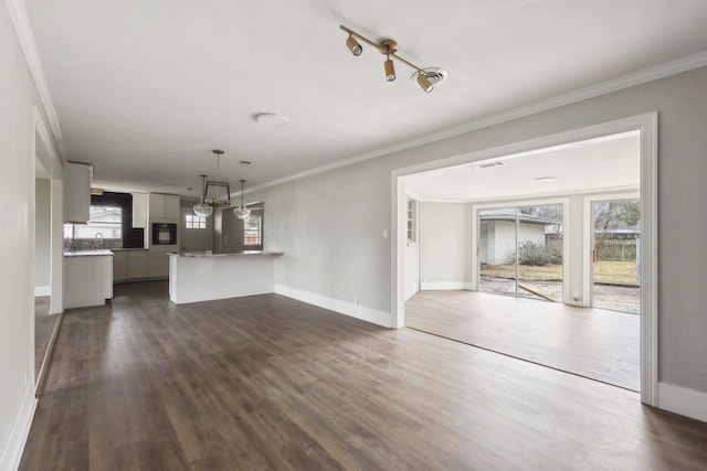 unfurnished living room with baseboards, dark wood-style flooring, crown molding, and visible vents