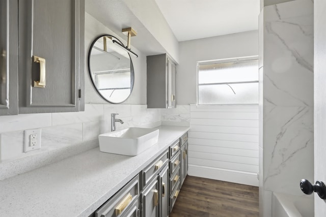full bathroom featuring a bathtub, tasteful backsplash, vanity, and wood finished floors