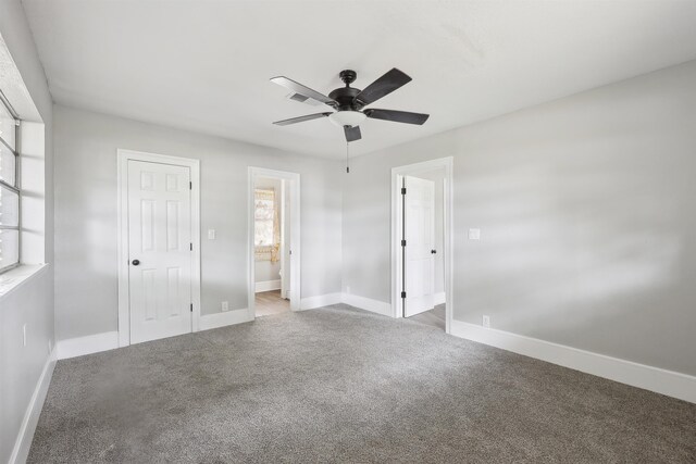 unfurnished bedroom featuring baseboards, carpet, ceiling fan, and connected bathroom
