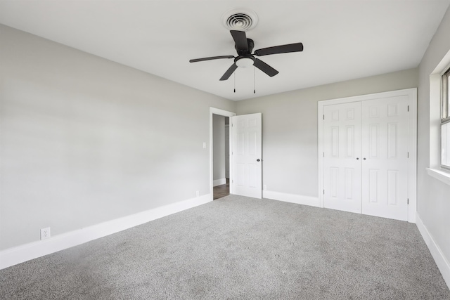 unfurnished bedroom with a closet, carpet, visible vents, and baseboards