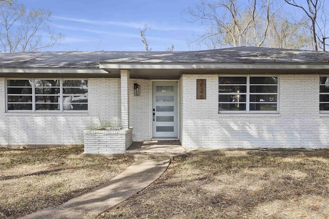 view of exterior entry with brick siding
