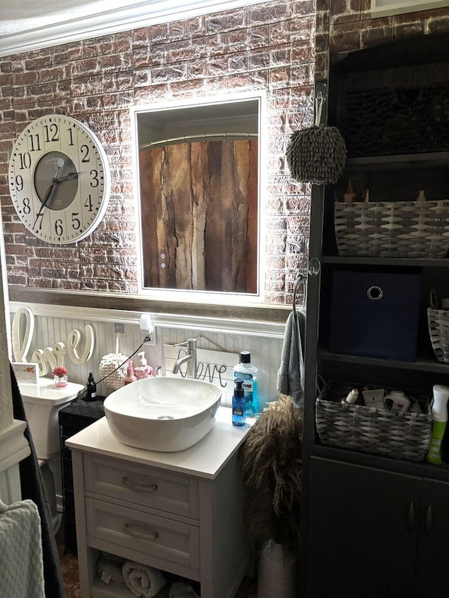 bathroom featuring vanity, a shower with shower curtain, and brick wall