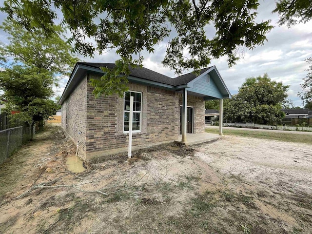 view of home's exterior with fence and brick siding