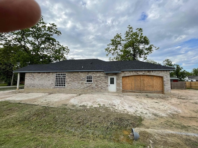back of property with a garage and fence