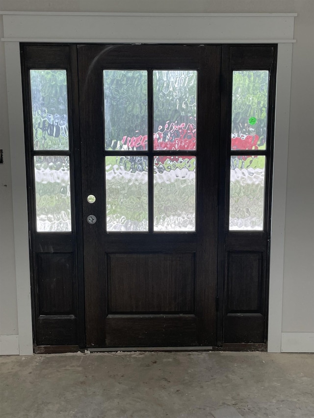 doorway to outside with unfinished concrete floors and french doors