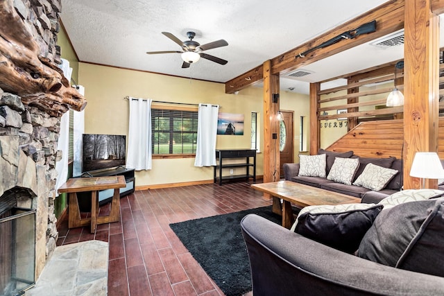 134 Sherwood Trl, Silsbee, TX 77656 - living room featuring ceiling fan, wood finished floors, a stone fireplace, beamed ceiling, and baseboards