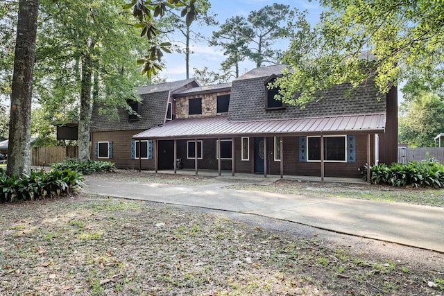134 Sherwood Trl, Silsbee, TX 77656 - view of front facade featuring a porch, metal roof, and driveway