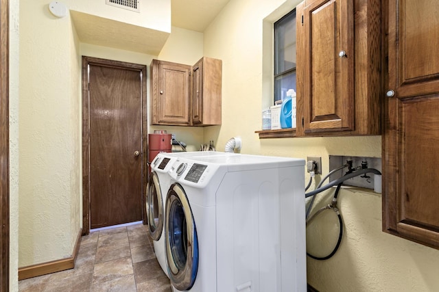 134 Sherwood Trl, Silsbee, TX 77656 - washroom with cabinet space, washing machine and dryer, a textured wall, and baseboards