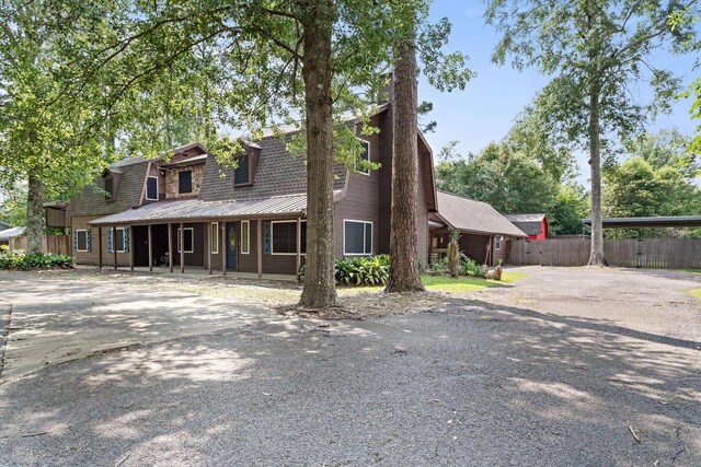 134 Sherwood Trl, Silsbee, TX 77656 - view of front of property with a porch, metal roof, and driveway