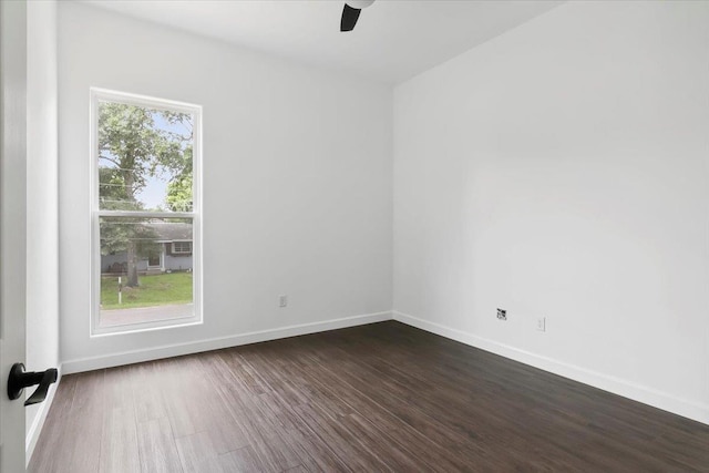 empty room with ceiling fan, a healthy amount of sunlight, and dark hardwood / wood-style floors