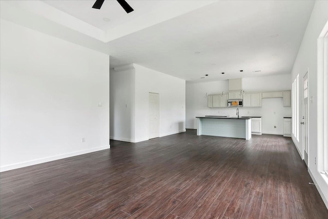 unfurnished living room with ceiling fan and sink