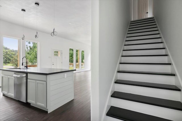 stairway featuring hardwood / wood-style floors, a healthy amount of sunlight, and sink