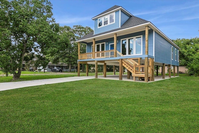 back of property with a yard, a porch, and a carport