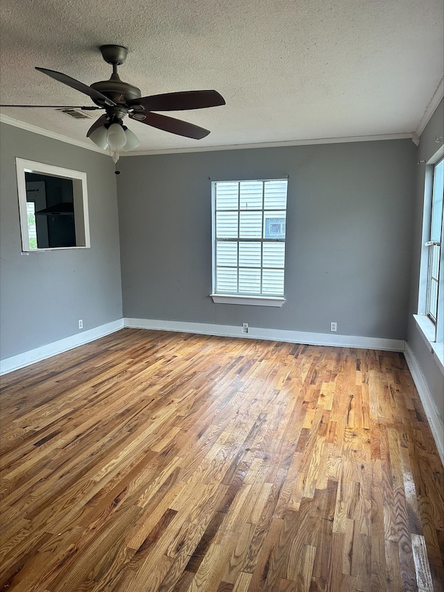 empty room with ceiling fan, light hardwood / wood-style flooring, a textured ceiling, and ornamental molding