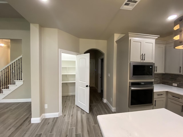 kitchen featuring decorative backsplash, hardwood / wood-style floors, and stainless steel appliances