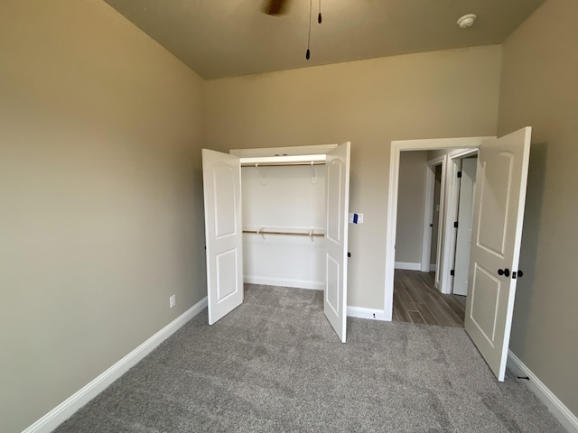 unfurnished bedroom featuring carpet floors, a closet, and ceiling fan