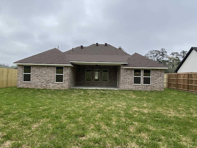 back of house with a yard and a patio