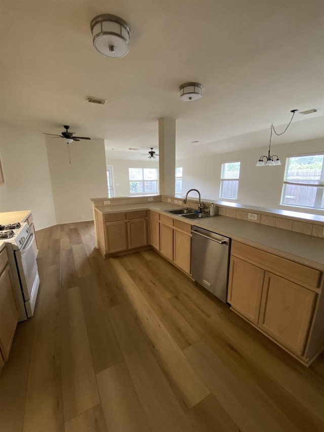 kitchen with visible vents, light brown cabinets, white gas stove, a sink, and dishwasher