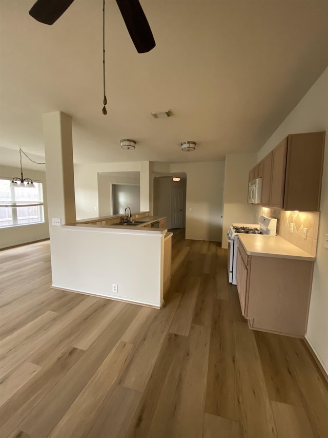 kitchen with visible vents, tasteful backsplash, light wood-type flooring, ceiling fan with notable chandelier, and white appliances
