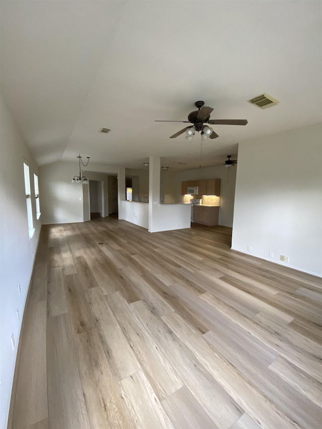 unfurnished living room featuring light wood-style floors, ceiling fan, vaulted ceiling, and visible vents