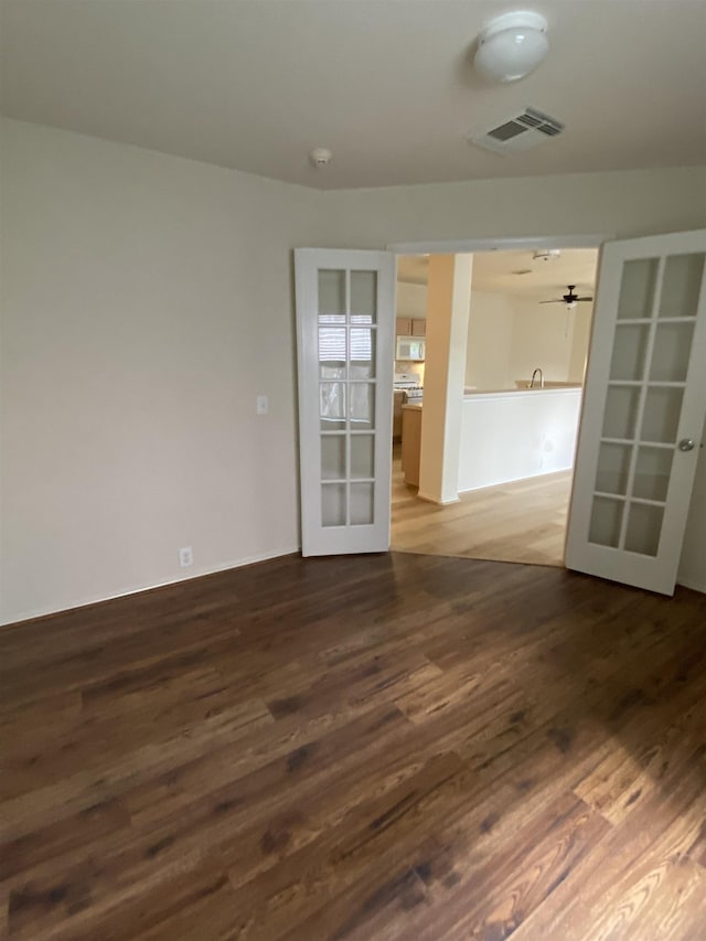 unfurnished room with french doors, dark wood-style flooring, and visible vents