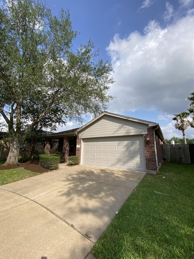 ranch-style house featuring a garage, fence, a front yard, brick siding, and concrete driveway