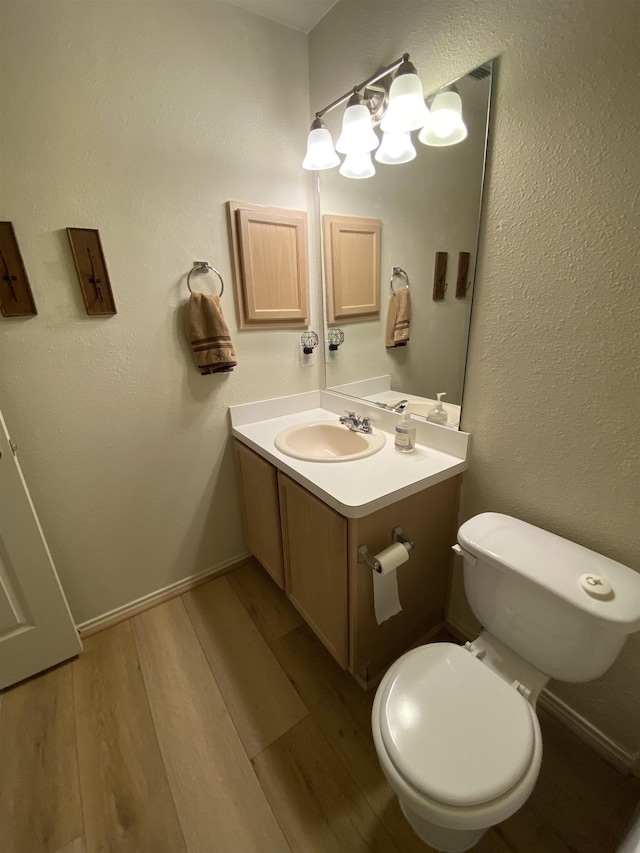 bathroom with vanity, toilet, and wood finished floors