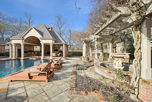 view of patio / terrace featuring an outbuilding, a bar, exterior fireplace, and a pergola