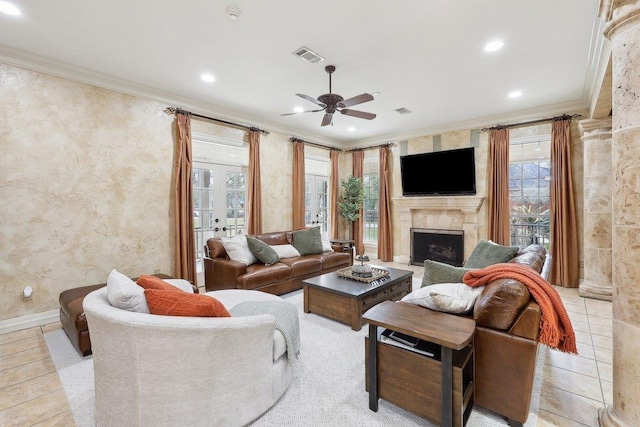 tiled living room featuring crown molding, ceiling fan, and a fireplace